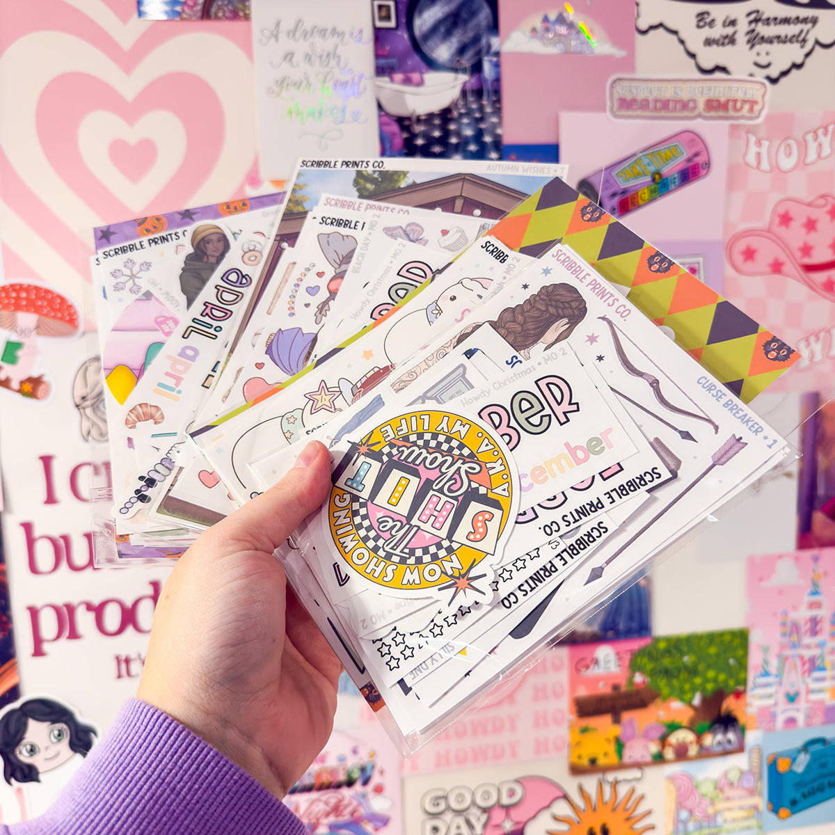 Hand holding bundles of matte paper stickers.